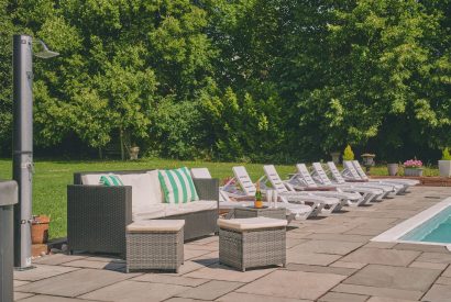 The outdoor seating area and sun loungers at Sharnbrook Retreat, Bedfordshire