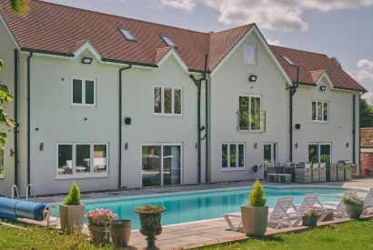 The back exterior with a swimming pool at Sharnbrook Retreat, Bedfordshire