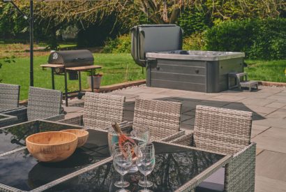 The outdoor dining table overlooking the hot tub at Sharnbrook Retreat, Bedfordshire