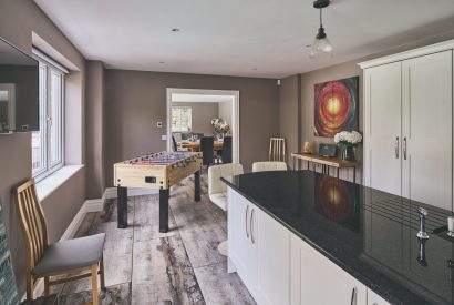 The kitchen with an island leading towards the dining room at Sharnbrook Retreat, Bedfordshire