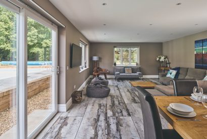 The open-plan living and dining room with doors onto the patio at Sharnbrook Retreat, Bedfordshire