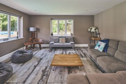 The living room with a view of the swimming pool at Sharnbrook Retreat, Bedfordshire