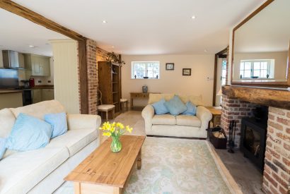 The living room with two sofas facing the log burner at Brightwaters Stables, Hampshire