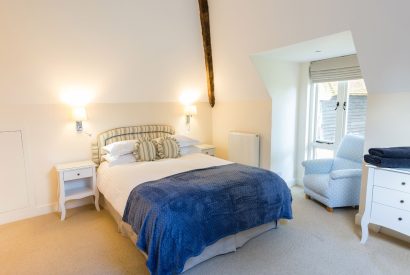 A double bedroom with an window seat at Brightwaters Stables, Hampshire