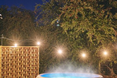 The outdoor hot tub at night at Windmill Old Orchard, Somerset