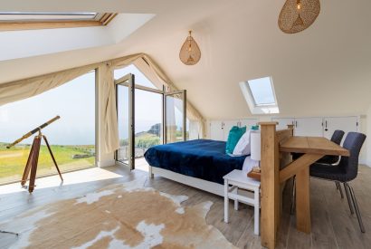 The master bedroom with French doors which overlooks the sea at Minack View, Cornwall