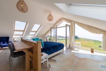 The master bedroom with French doors which overlooks the sea at Minack View, Cornwall