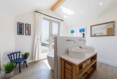 A bathroom with free standing bath and jack and jill sinks at Minack View, Cornwall