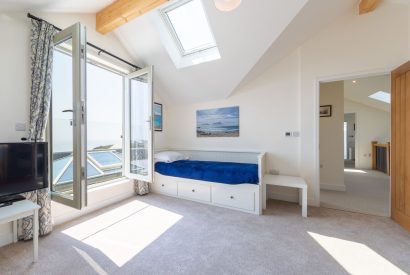A single bedroom with French door which overlook the sea view at Minack View, Cornwall