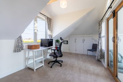 An office with a small desk and chair at Minack View, Cornwall