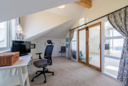 An office with a small desk and chair attached to the bedroom at Minack View, Cornwall