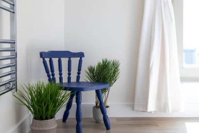 A blue wooden chair in the corner of the bathroom at Minack View, Cornwall