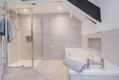 The family bathroom with a rainfall shower and bath at Rose Walls, Lake District 