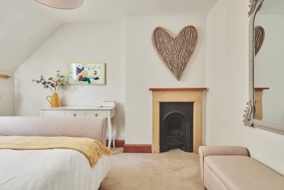 A bedroom with a fireplace at Ember Cottage, Cotswolds