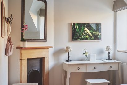A fireplace and dressing table at Ember Cottage, Cotswolds