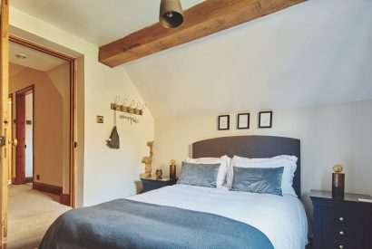 A bedroom with beams at Ember Cottage, Cotswolds