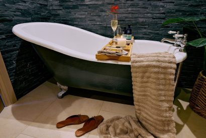 A free-standing bath with a glass of champagne at Stable Barn in the Cotswolds