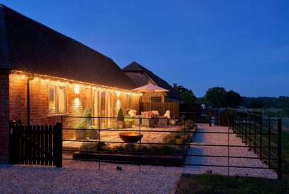 The exterior of the barn at night with the fairy lights switched on at Stable Barn, Cotswolds 