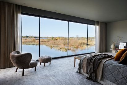 The master bedroom with lake view at The Reserve, Cotswolds