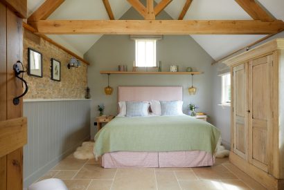 A double bedroom with beams at Milk Barn, Cotswolds