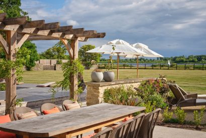 The outdoor dining table and countryside views at Lakeside Manor, Cotswolds