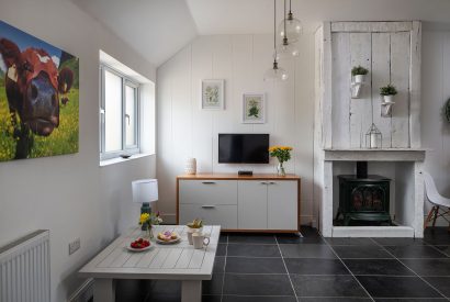 The open plan living and dining space with a log burner at Little Calf Cottage, Wiltshire