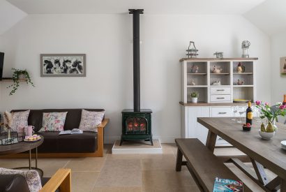 The living and dining room with a log burner at Farmyard Cottage, Wiltshire