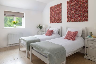 A twin bedroom with garden view at Farmyard Cottage, Wiltshire
