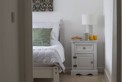 A double bedroom with breakfast on the bedside table at Farmyard Cottage, Wiltshire