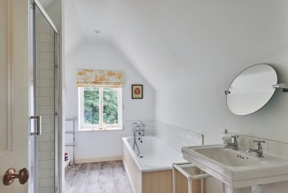 The family bathroom with a bath and shower at Withington Grange, Cotswolds 
