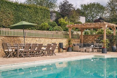 The outdoor pool and seating area at Withington Grange, Cotswolds 