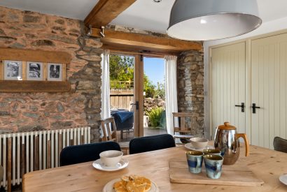 The dining table with doors onto the patio at Chapel Cottage, Pembrokeshire