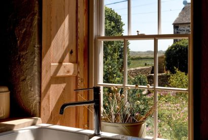 A sink in front of the window overlooking the countryside at Chapel Cottage, Pembrokeshire