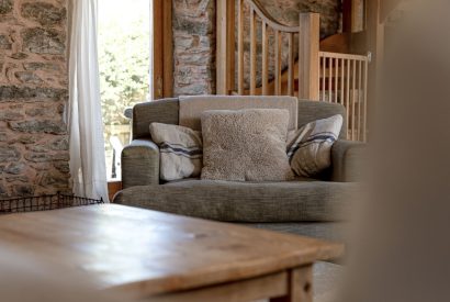 A sofa in the living room with a coffee table at Chapel Cottage, Pembrokeshire