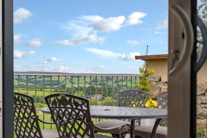 The patio with a dining table overlooking the moorlands at High Moor Cottage, Yorkshire