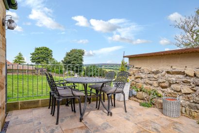 A dining table on the patio overlooking the countryside at High Moor Cottage, Yorkshire