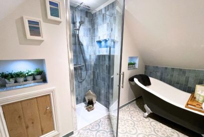 The bathroom with a free standing bath and walk in shower at Piglet's Hideaway, Cotswolds