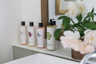 Luxury bath products on the bathroom shelf at Rambling Rose Cottage, Cotswolds