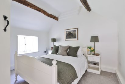 The master bedroom with oak beams at Rambling Rose Cottage, Cotswolds