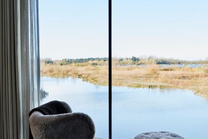 The master bedroom with lake view at The Reserve, Cotswolds