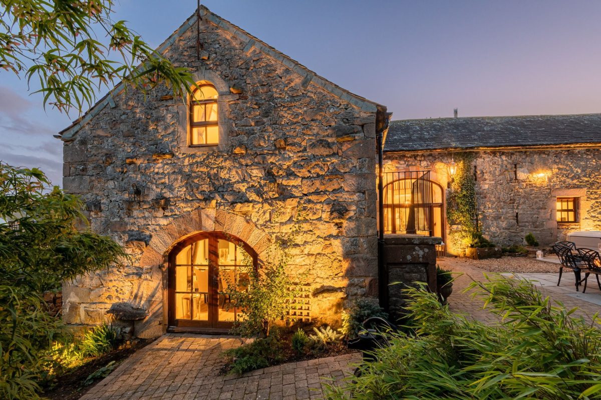 The exterior of the cottage at night at Rose Walls, Lake District 