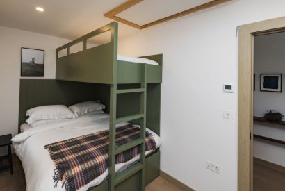 King size bed with bunk bedroom at Map Maker's Cottage, Roundstone, Galway