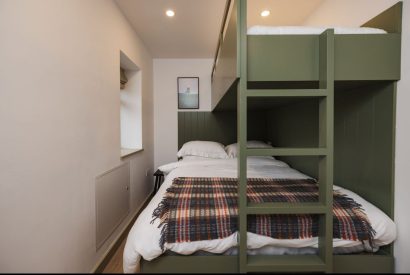 King size bed with bunk bedroom at Map Maker's Cottage, Roundstone, Galway