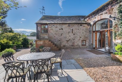 The private patio with a dining table and chairs at Rose Walls, Lake District 