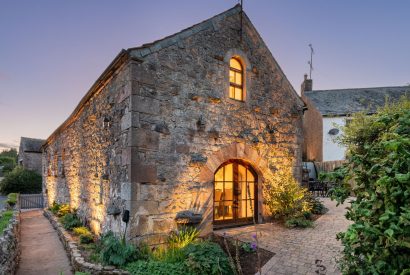 The exterior of the cottage at night at Rose Walls, Lake District 