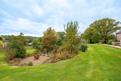 The private lawned garden and fire pit at Tinkers Folly, Yorkshire