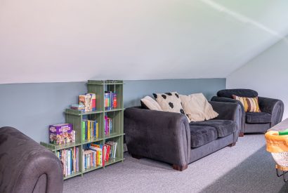 The sofas and books in the games room at Tinkers Folly, Yorkshire