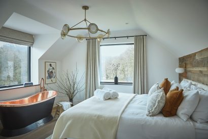 A super king size bedroom with Copper bath at Copeland House, Lake District
