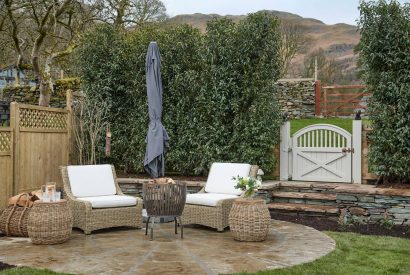 An outdoor seating area and fire pit at Beatrix Cottage, Lake District