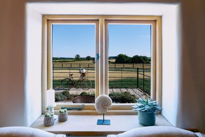 The view of a Pashley bicycle and the field beyond from the front window of Stable Barn in the Cotswolds